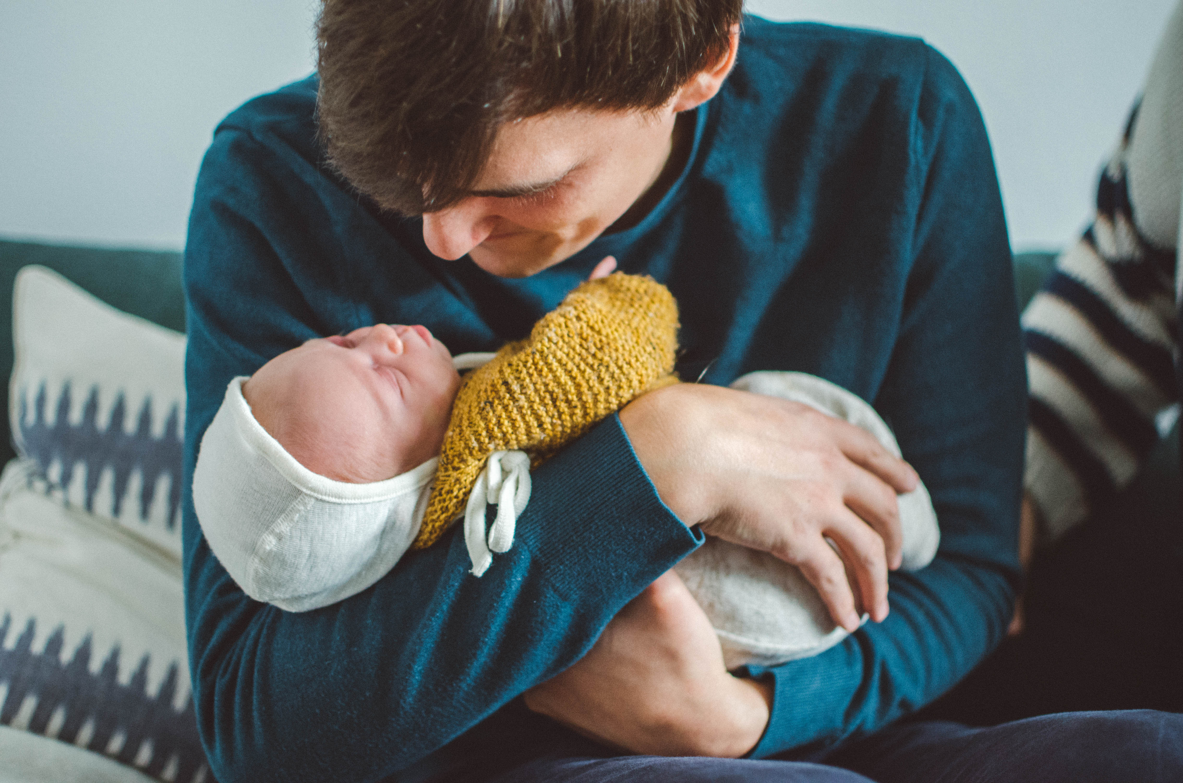 Vater mit seinem Neugeborenem auf dem Arm, babyfotograf basel