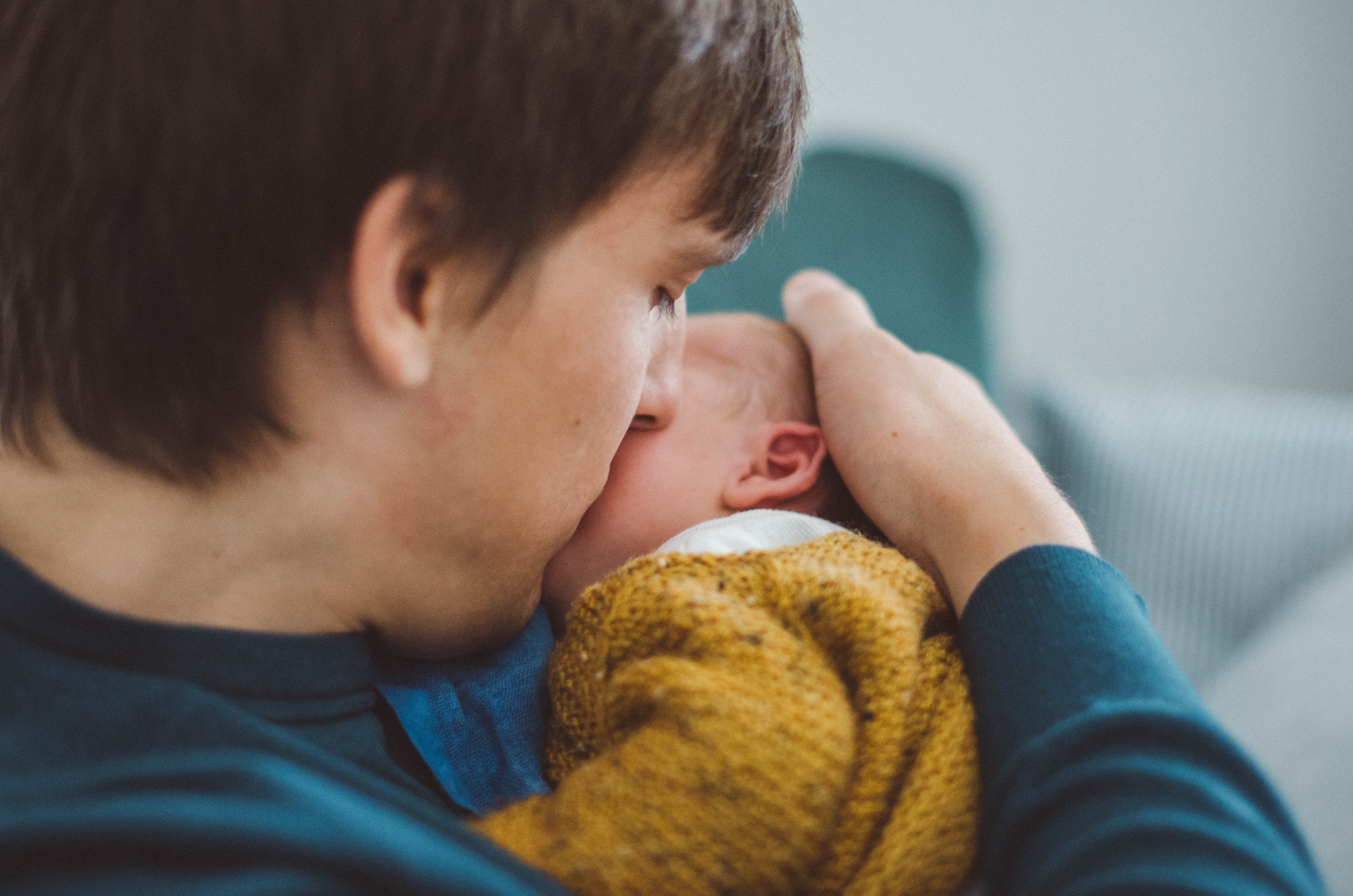 Vater küsst sein Neugeborenes, babyfotograf basel