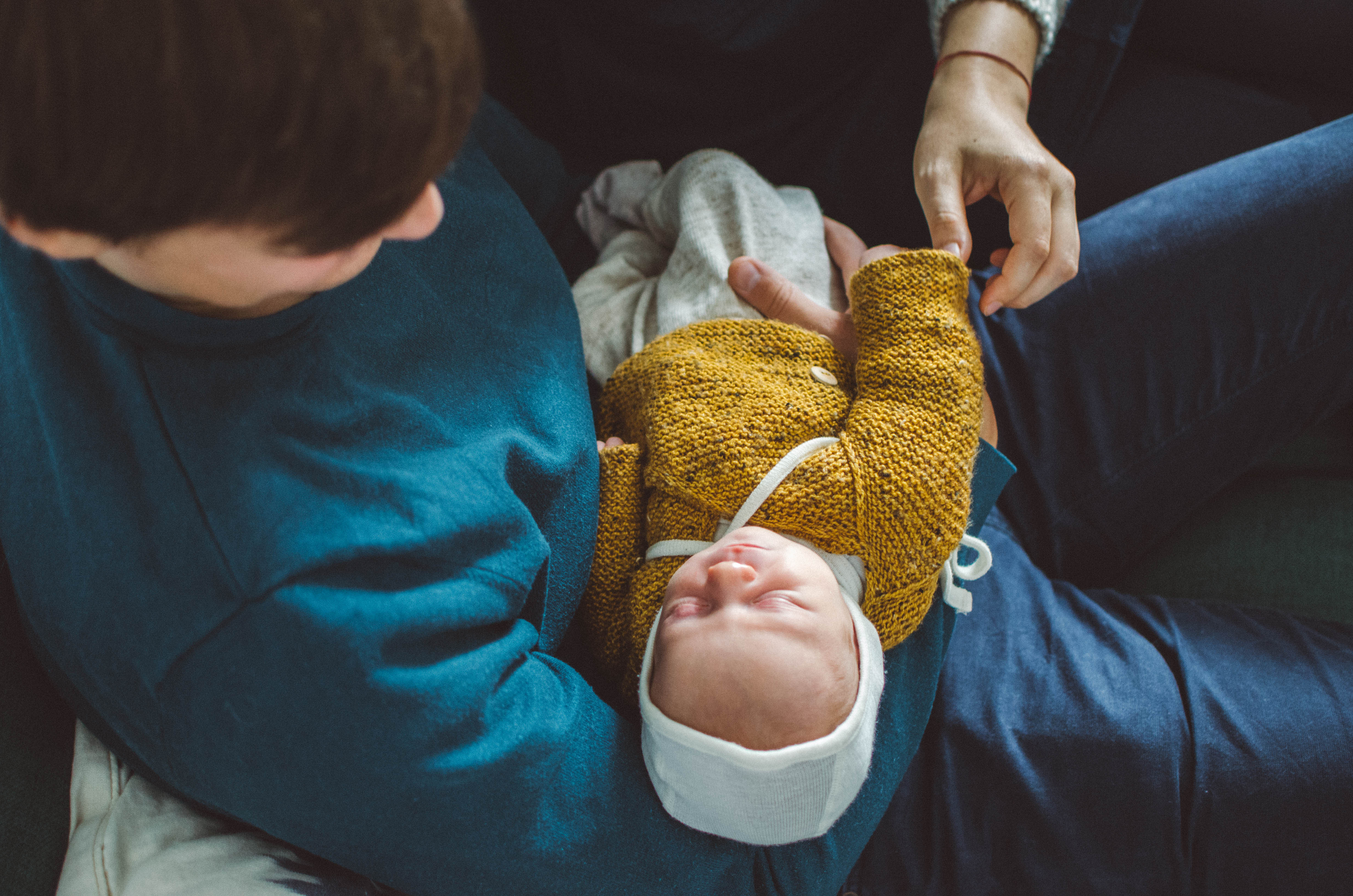 Neugeborenes auf dem Arm seines Vaters, babyfotograf basel