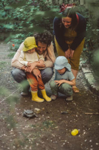 Familie mit zwei Kindern beobachtet Schildkröte bei Familien Fotoshooting Freiburg