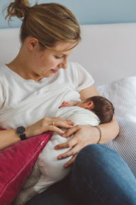 Mutter stillt ihr Baby bei Neugeboren Fotoshooting Basel