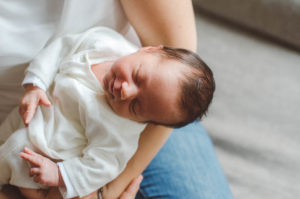 Neugeborenes schläft im Arm der Mutter bei Neugeboren Fotoshooting Basel