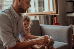 Vater hilft Tochter die Schuhe anzuziehen Foto entstanden bei Familienfotoshooting in Basel