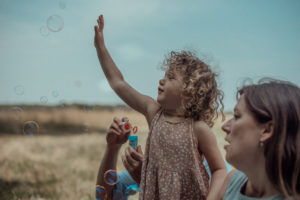 Kind fängt Seifenblase Foto entstanden bei Familienfotoshooting Basel