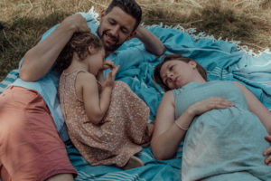 Familie mit Kind auf Picknickdecke entstanden bei Familienfotoshooting im Park Basel