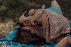 Mutter und Kind kuscheln auf Picknickdecke bei Familienfotoshooting in Basel