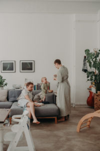Eine Familie mit Baby in ihrem Wohnzimmer bei Familienfotoshooting Zuhause in Freiburg