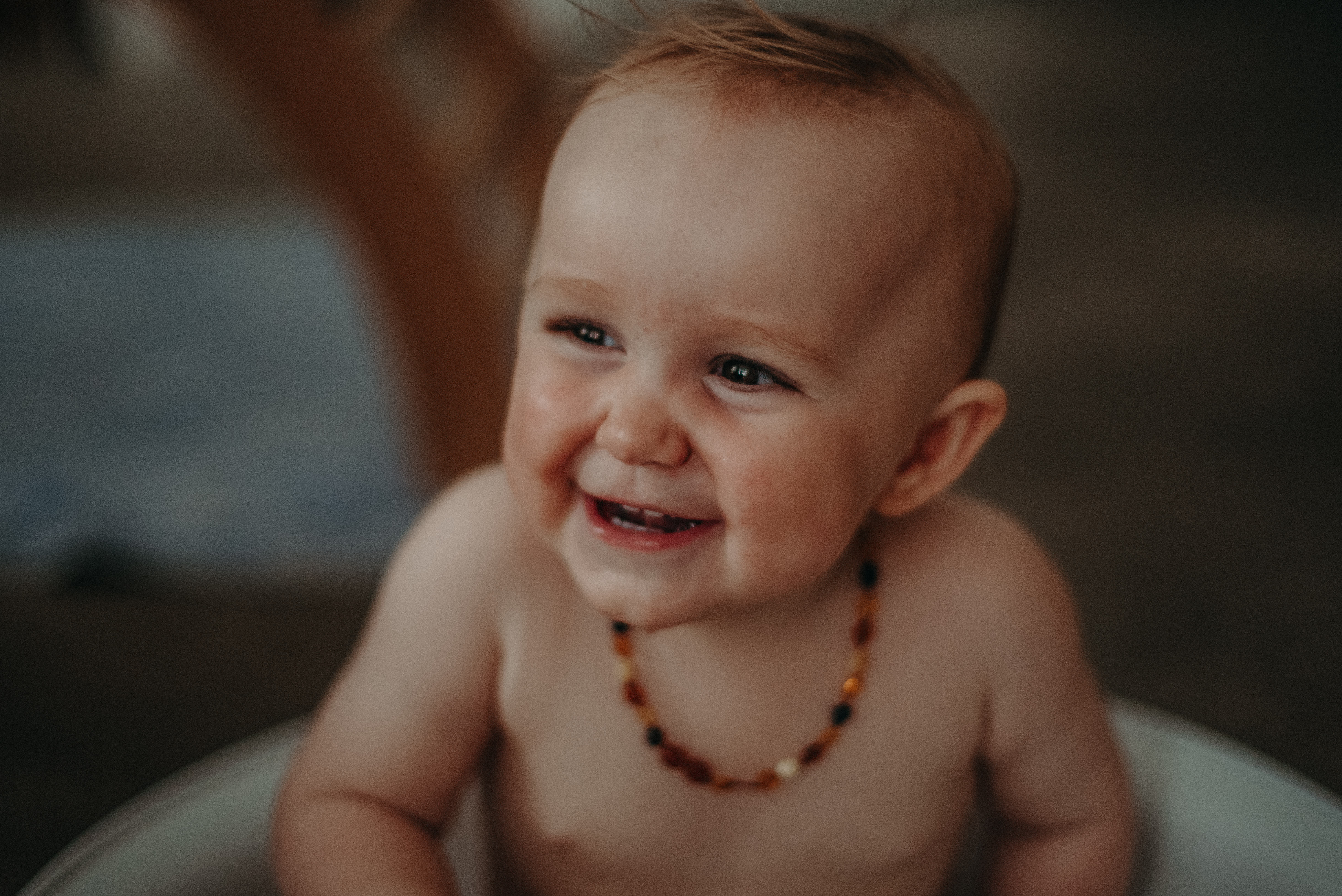 Lachendes Babyfoto mit Bernsteinkette von Natürliches Mutter Kind Portrait Zuhause, babyfotograf basel