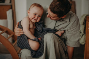 Lachendes Baby im Arm der Mutter von Familienfotograf Freiburg