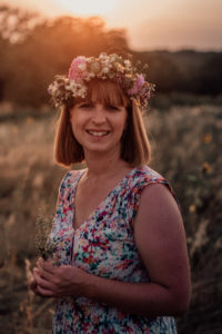 Frau mit Blumenkranz im Sonnenuntergang bei einem Blumenkranzworkshop in Müllheim Baden im Markgräflerland