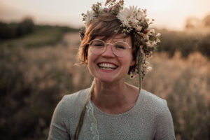 Lachende Frau mit Blumenkranz bei Sonnenuntergang im Markgräflerland Müllheim bei einem fotoshooting