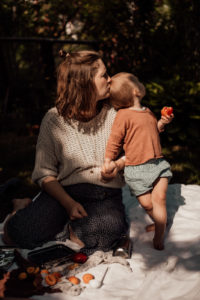 Mutter küsst ihr Kleinkind Foto entstanden bei Familienfotoshooting mit Picknick im Garten Freiburg