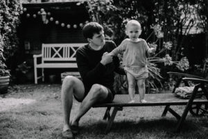 Vater mit kleiner Tochter im Garten fotografiert von Familienfotograf Freiburg