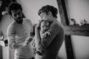Schwarz Weiß Foto einer Familie mit Neugeborenen entstanden bei einem Neugeborenenfotoshooting bei Freiburg