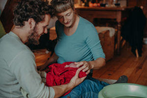 Foto vom ersten Babybad entstanden bei einem Fotoshooting mit Neugeborenen Zuhause im Wochenbett bei Freiburg