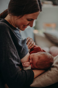 Neugeborenenfoto Stillfoto von Mutter die ihr Baby stillt entstanden bei Neugeborenenfotoshooting in Freiburg