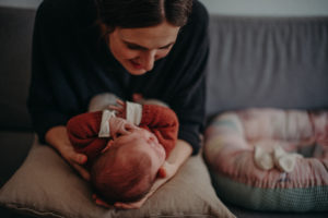 Neugeborenenfoto von Baby auf dem Schoß der Mutter entstanden bei Neugeborenenfotoshooting in Freiburg