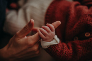 Neugeborenenfoto von Babyhand die den Finger der Mutter festhält entstanden bei Neugeborenenfotoshooting in Freiburg