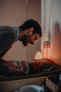 Neugeborenenfoto von Baby mit Papa und Stoffwindeln entstanden bei Babyfotoshooting Zuhause in Freiburg
