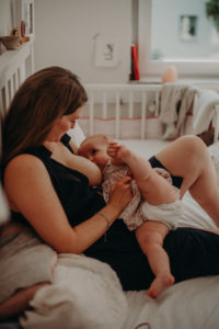 Mutter stillt Kind mit Augenkontakt, natürliches Familienfoto entstanden bei Familienfotoshooting in Freiburg