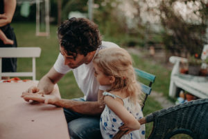 Vater und Tochter betrachten Schmetterling, natürliches Familienfoto entstanden bei Familienfotoshooting in Freiburg