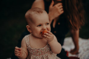 Baby mit Apricose, natürliches Familienfoto entstanden bei Familienfotoshooting in Freiburg
