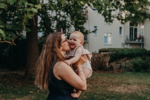 Babyfoto von lachender Mutter und Baby, natürliches Familienfoto entstanden bei Familienfotoshooting in Freiburg