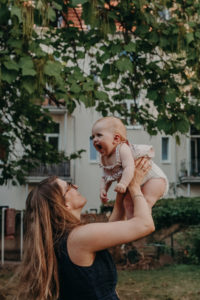Babyfoto von Baby mit Mutter im Garten, natürliches Familienfoto entstanden bei Familienfotoshooting in Freiburg