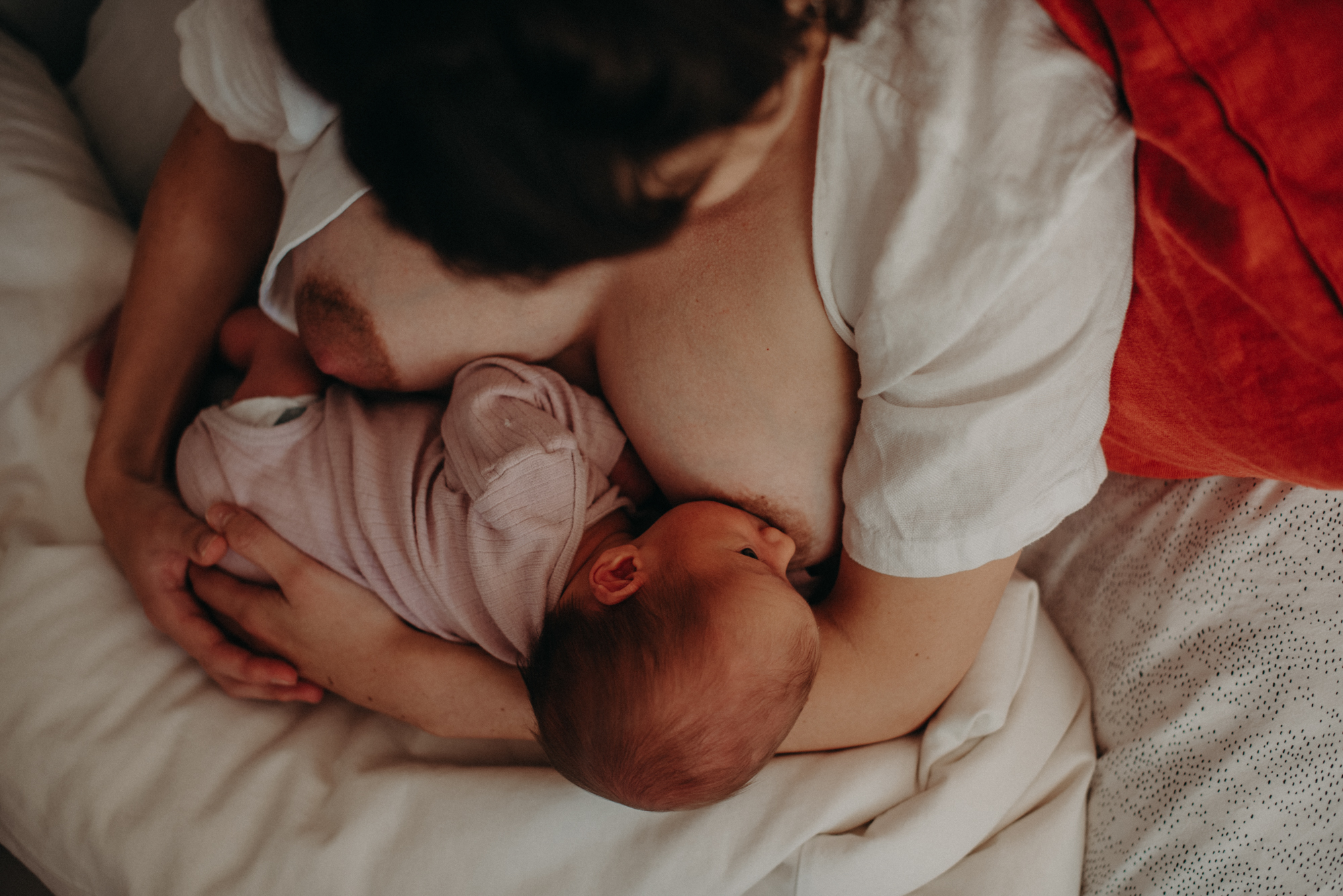 Mutter stillt Neugeborenes, Blogpost Babyfotoshooting selber machen, Fotograf in Freiburg