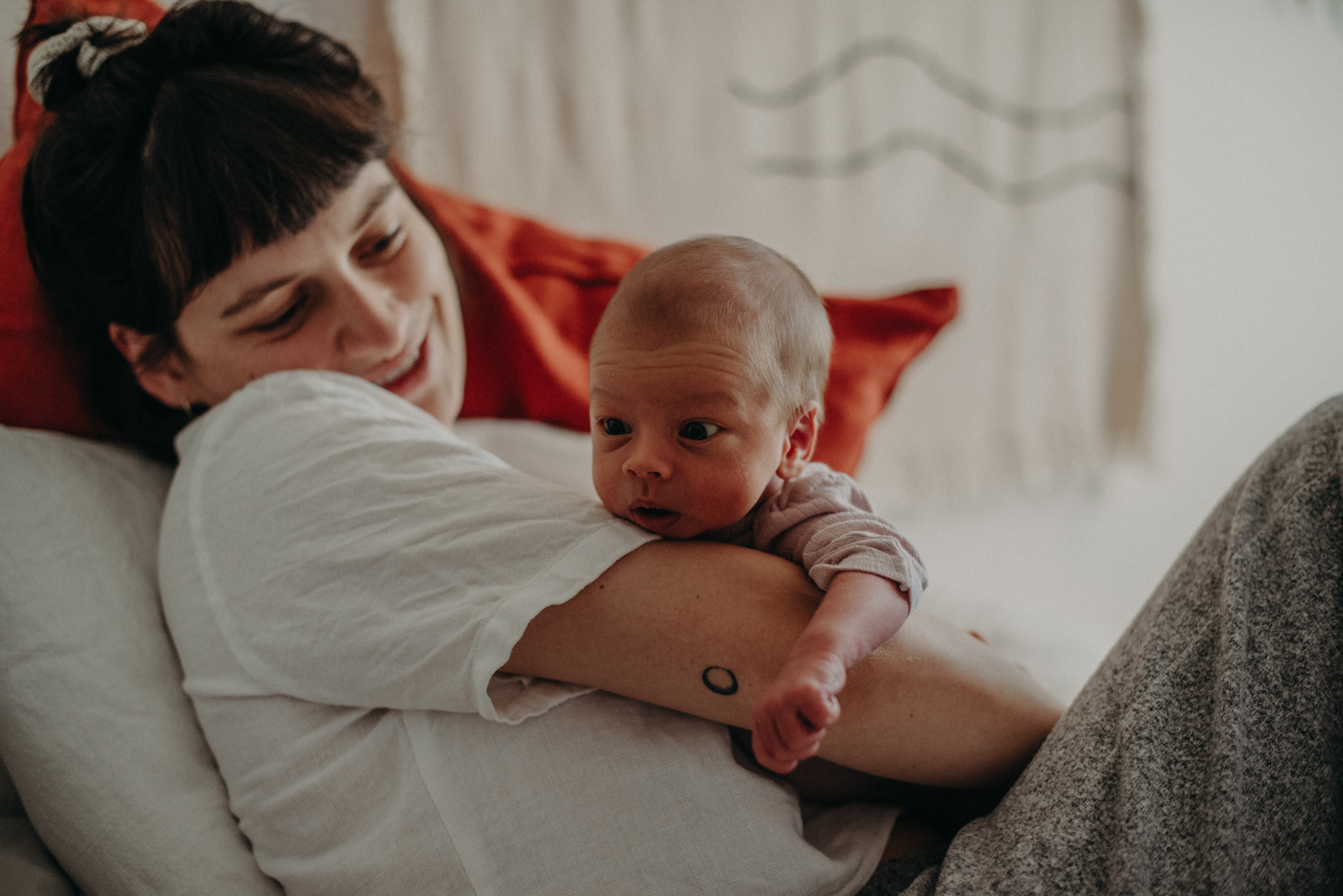 Neugeborenes auf dem Arm der Mutter mit großen Augen, Fotograf in Basel