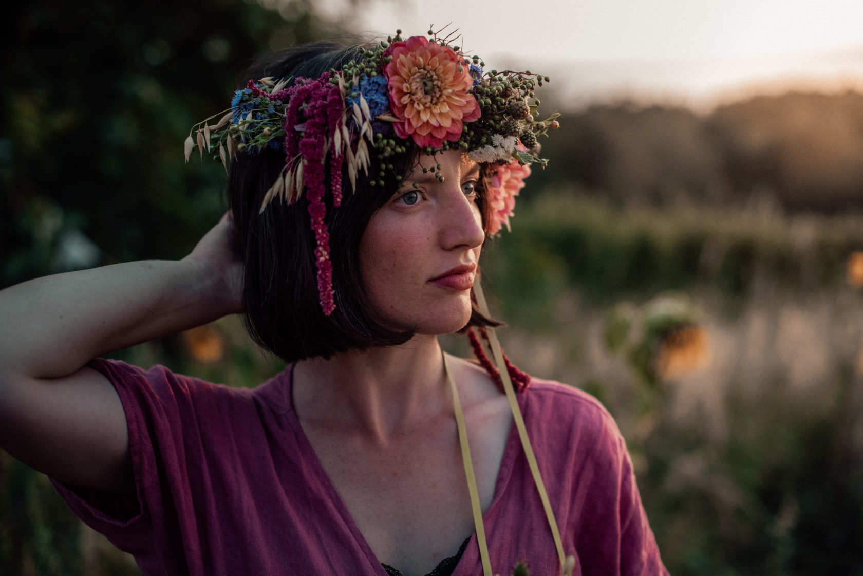 Frau mit Blumenkranz und rosa Kleid bei Sonnenuntergang im Markgräflerland Müllheim bei einem fotoshooting