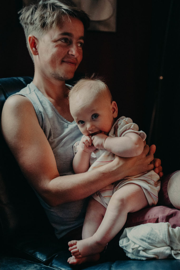 Stockfotos lgbtqia+ Ein Trans Vater hält lächelnd sein Kind