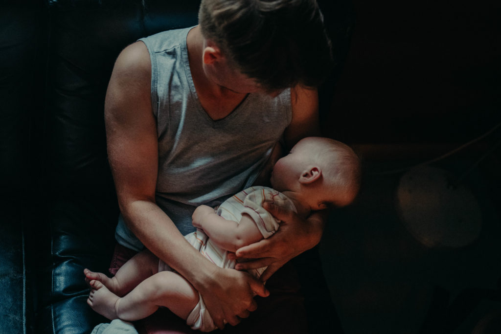 Stockfotos lgbtqia+ ein Trans Vater stillt sein Baby in einem Café und schaut es an