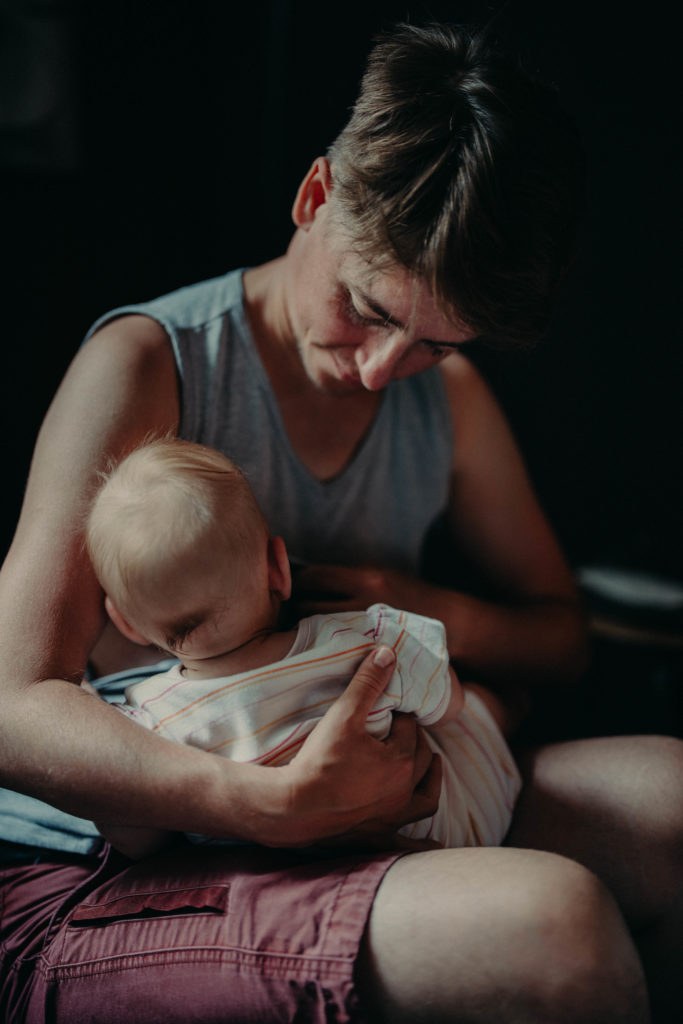 Stockfotos lgbtqia+ Trans Vater stillt sein Baby in einem Café