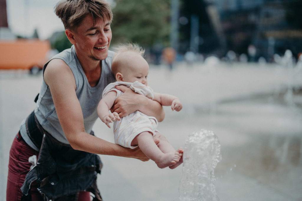 Stockfotos lgbtqia+ Trans Vater spielt mit Baby am Wasser