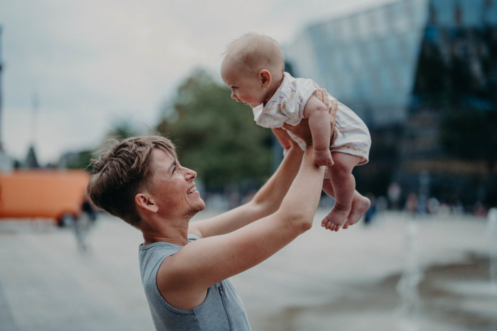 Stockfotos lgbtqia+ Trans Vater hebt Baby in die Luft